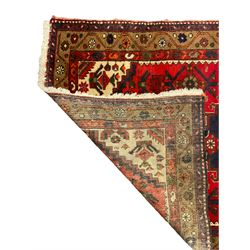 Persian Hamadan rug, red ground field decorated with pole medallion and stylised flower head motifs, the border decorated with Boteh and floral motifs