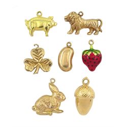 Seven 9ct gold pendant / charms including lion, acorn, enamelled strawberry, rabbit, coffee bean, clover and pig 