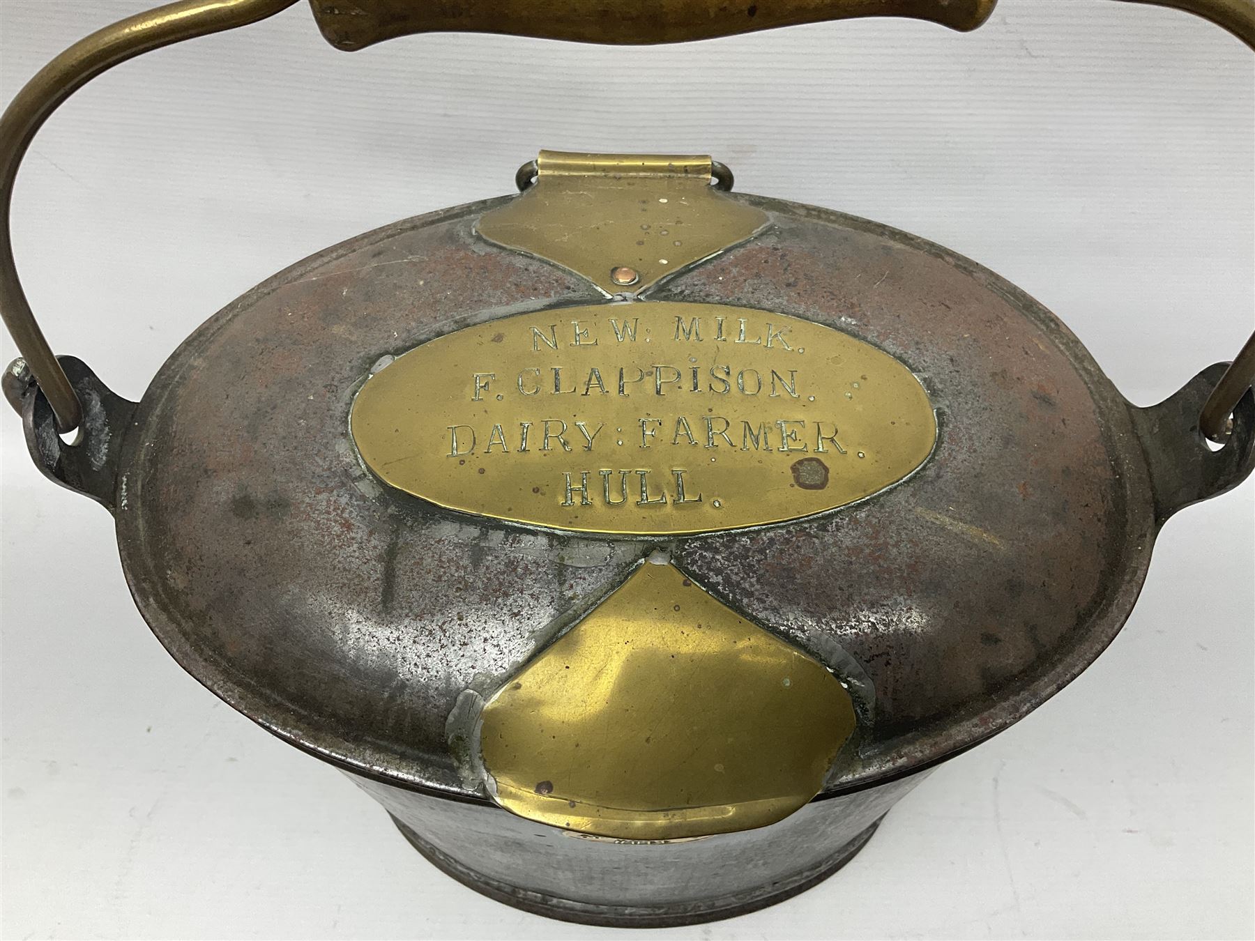 Late 19th/early 20th century steel and brass dairy pail or can, of oval form with swing handle, brass plaque to front and hinged cover inscribed 'F & T Ross Ltd Dairy Outfitters Hull', and 'New Milk F Clappison Dairy Farmer Hull', not including handle H30cm