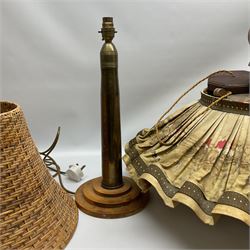 Trench Art shell lamp upon a stepped circular base, together light fitting with an umbrella shade depicting a hunting scene and a wicker lamp shade