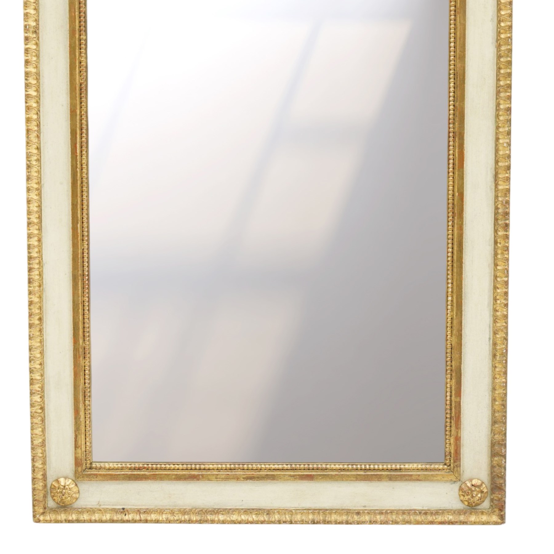 Neoclassical design pair of cream painted and gilt pier mirrors, projecting moulded cornices above frieze panels decorated with ribbon-tied musical trophies, rectangular plates within beaded slips, the outer frames with repeating leaf borders and flowerhead roundels