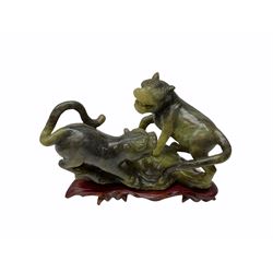 Group of Oriental hardstone and soapstone figures, comprising pair of seated temple lions upon plinth bases, model of a water ox with boy seated upon its back, dragon turtle, and figure group carved as two dogs of foo or lions. 