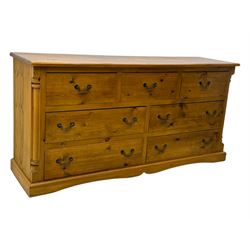 Pine dresser, rectangular top above seven drawers, with two smaller drawers over five larger drawers, all fitted with cast metal handles, raised on a shaped plinth base

