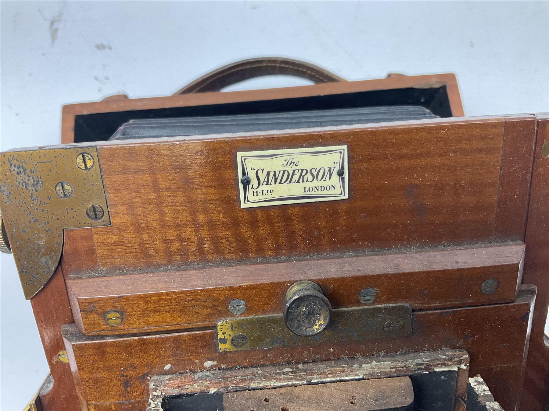 Ensign 'The Sanderson' folding plate camera in mahogany and lacquered brass, field model with canvas wrapped box, two mahogany photographic plates, 'Busch rapid Symmetrical F:8' lens,  and a wooden tripod 