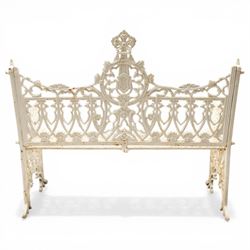 Victorian revival heavy cast iron garden bench, ornate back rest with scrolls, floral motifs and central crest, pierced lattice seat, curved arms and decorative legs, painted in antique white, in the Gothic Coalbrookdale style