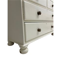 Victorian cream painted pine cupboard-on-chest or housekeeper's cupboard, projecting cornice over two double-arch panelled cupboard doors enclosing two shelves, flanked by spiral turned uprights, base fitted with two short over two long drawers, on bun feet