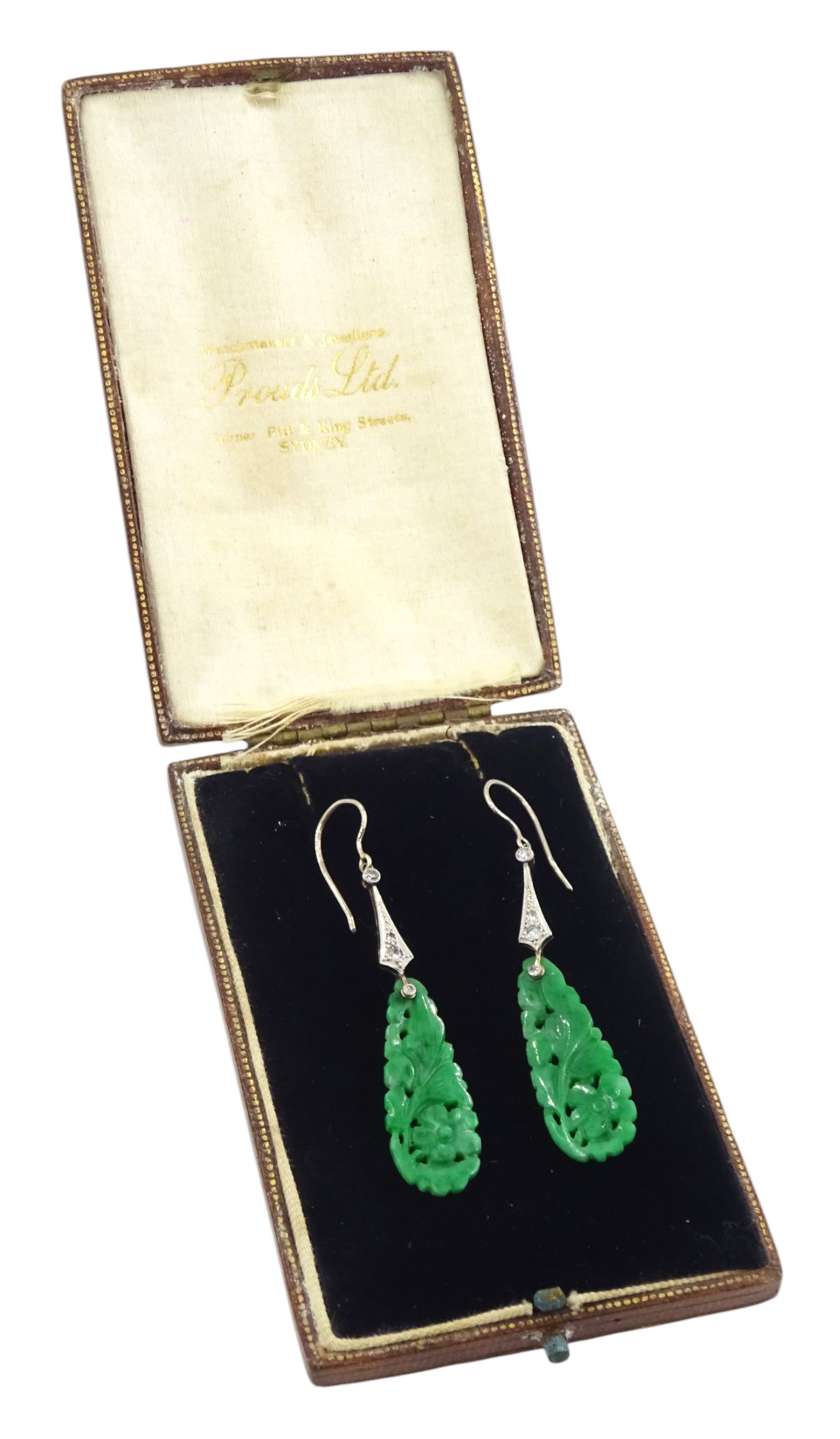 Pair of 18ct white gold Art Deco jade and diamond earrings, the pear shaped jade panels, with carved foliate decoration, suspending from milgrain set single and old cut diamond pendants, in velvet and silk lined box by Prouds Ltd, Sydney