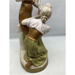 Royal Dux figure group, The Blacksmiths Family, modelled as a man in work clothes and holding a sledgehammer, with kneeling mother supporting young boy, with stamped and impressed mark beneath H61cm