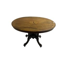Late 19th century walnut loo table, oval top inlaid with foliate decoration and stringing, five turned columns united by circular base, raised on four acanthus leaf and scroll carved cabriole supports with brass and ceramic castors