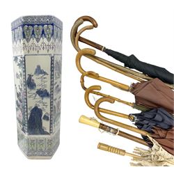 Oriental hexagonal walking stick stand, decorated with panels depicting mountain scenes and birds, together with walking sticks and umbrellas, stand H62cm 