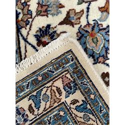 Persian Kashan ivory ground rug, the central medallion surrounded by an arrangement of palmettes united by scrolling leafy branches, peach ground main border decorated with trailing leaf and stylised plant motifs, floral pattern guard stripes 