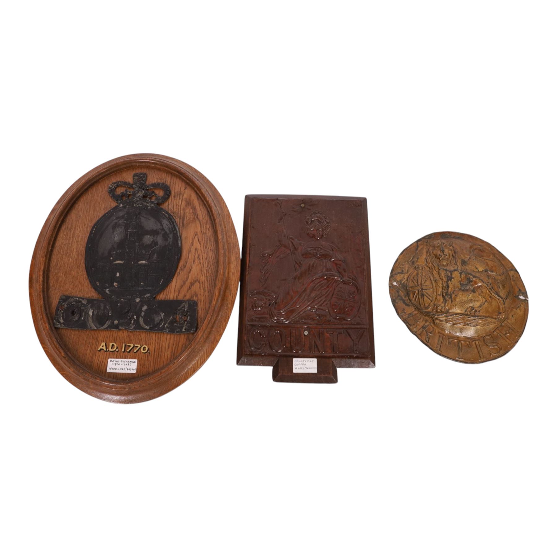 Two 19th century fire insurance marks, comprising tin County Fire Office, mounted upon oak backing, Lead Royal Exchange Assurance, mounted upon circular oak frame, together with a Milners' Fire Resisting Safe plaque, 