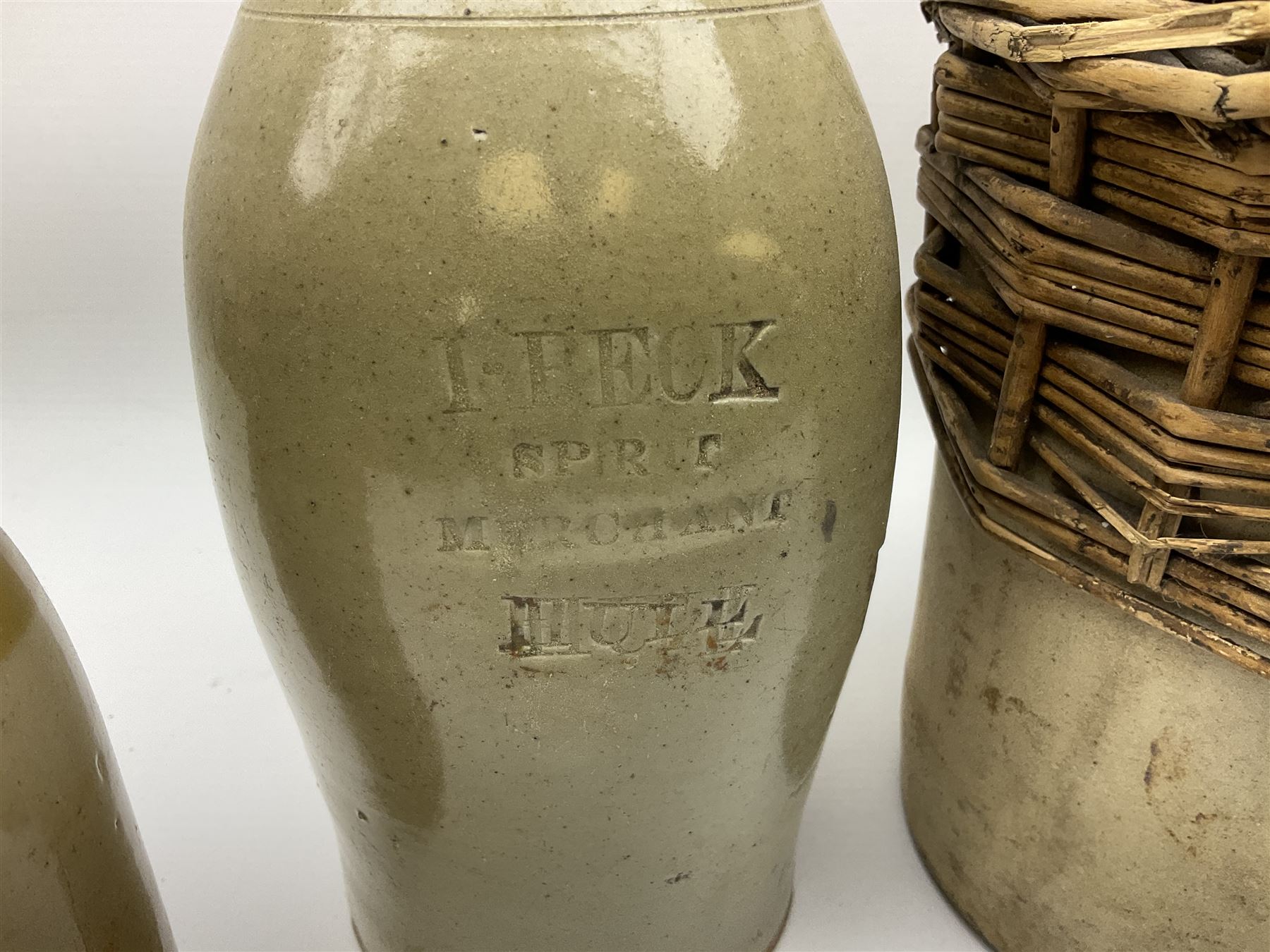 19th century stoneware gin bottle impressed I. Peck, Spirit Merchant Hull H27cm, Victorian salt glazed stoneware jar embossed W. Jefferson Mustard Manufacturer 47 Wincolmlee Hull, part cane covered stoneware flagon for John Smith Market Place Beverley and a Barton-on-Humber stoneware ginger beer bottle (4)  