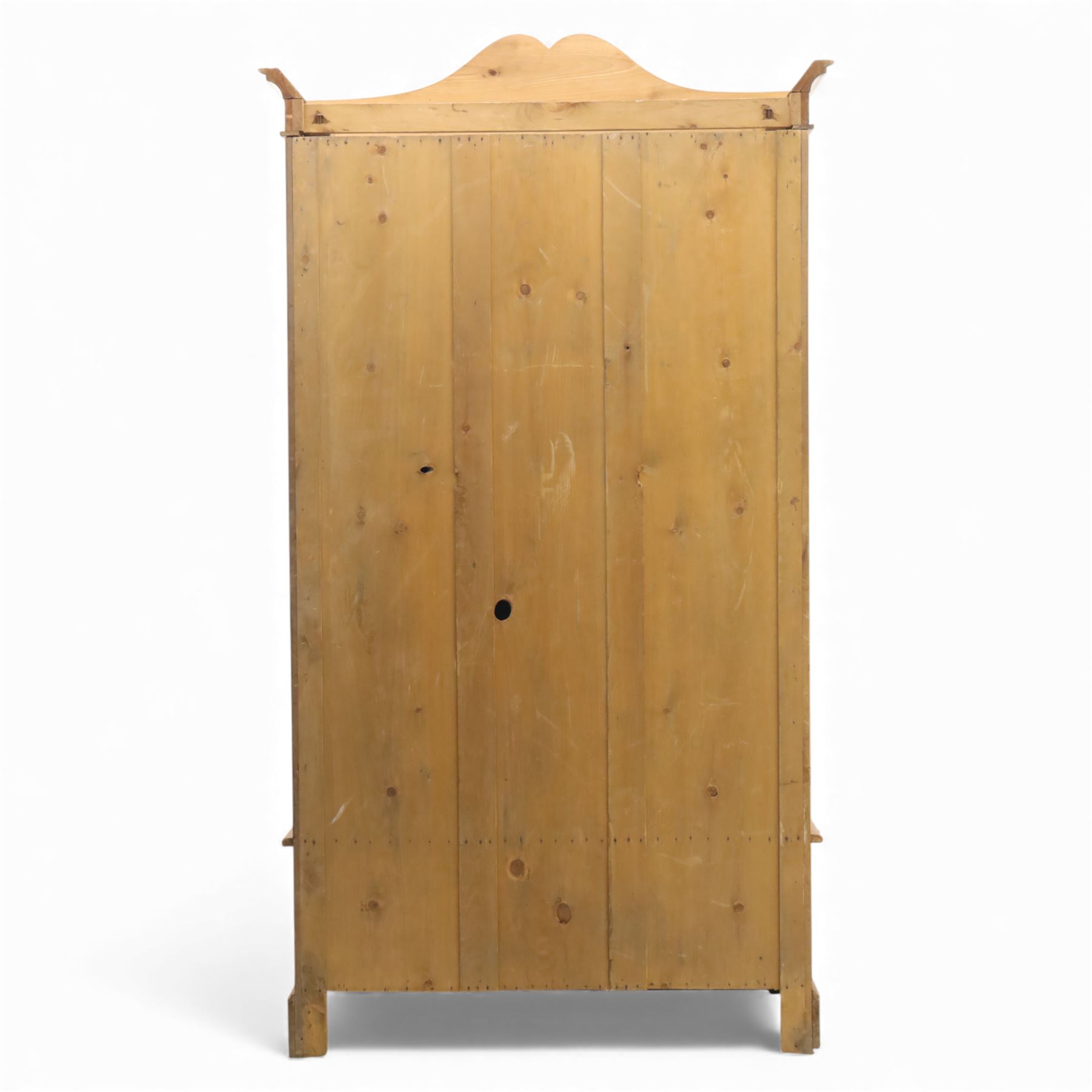 Victorian satin walnut single door wardrobe, shaped cavetto cornice above a central arched mirrored door flanked by recessed panelled sides, the interior fitted with hanging space and later added corner shelves, over a single long drawer with brass handles, on a plinth base