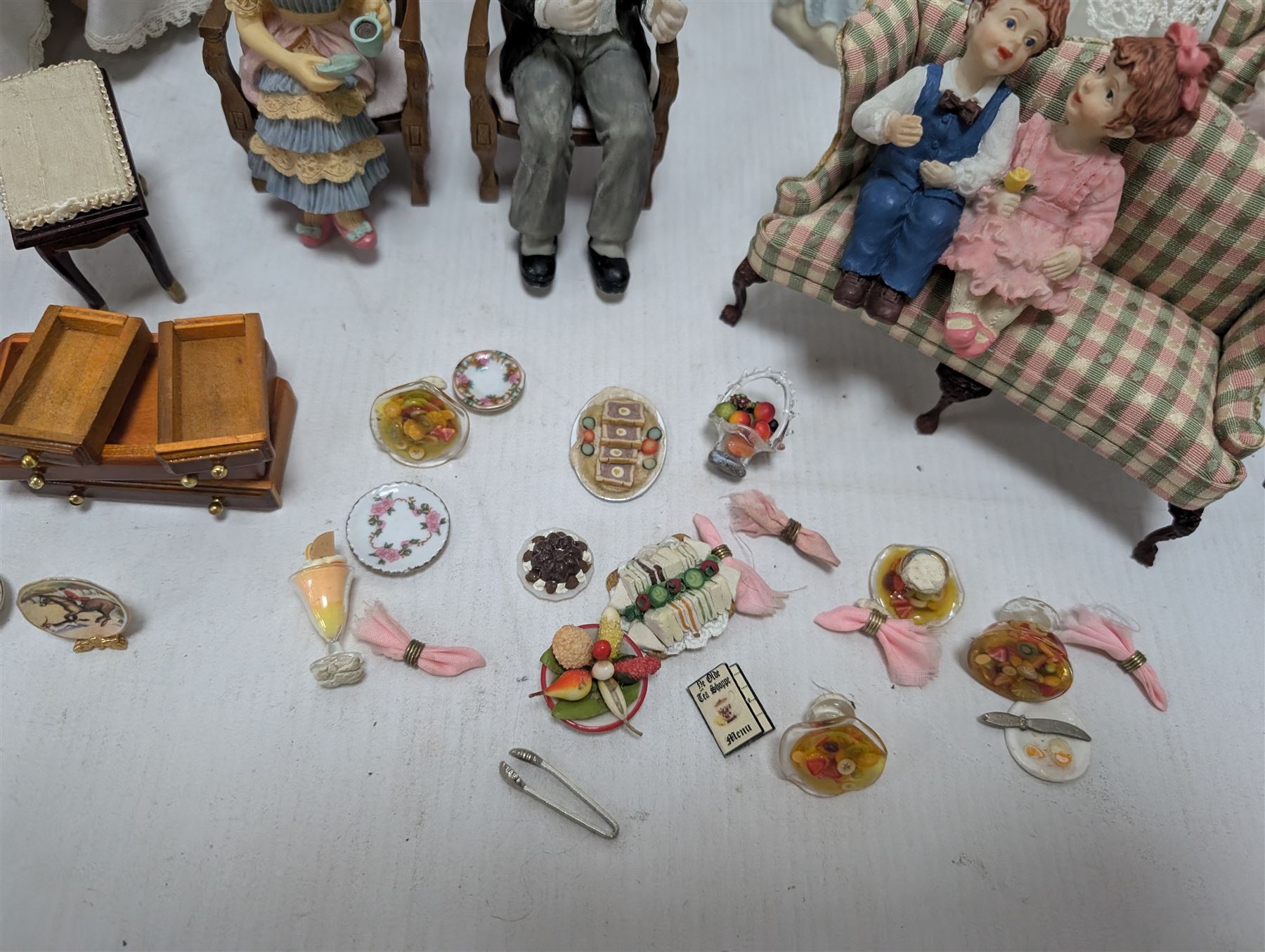 Dolls house drawing room furniture, including dressers, pink and green checked sofa and armchairs, bureau, chairs, piano, eight figures and a collection of afternoon tea miniatures