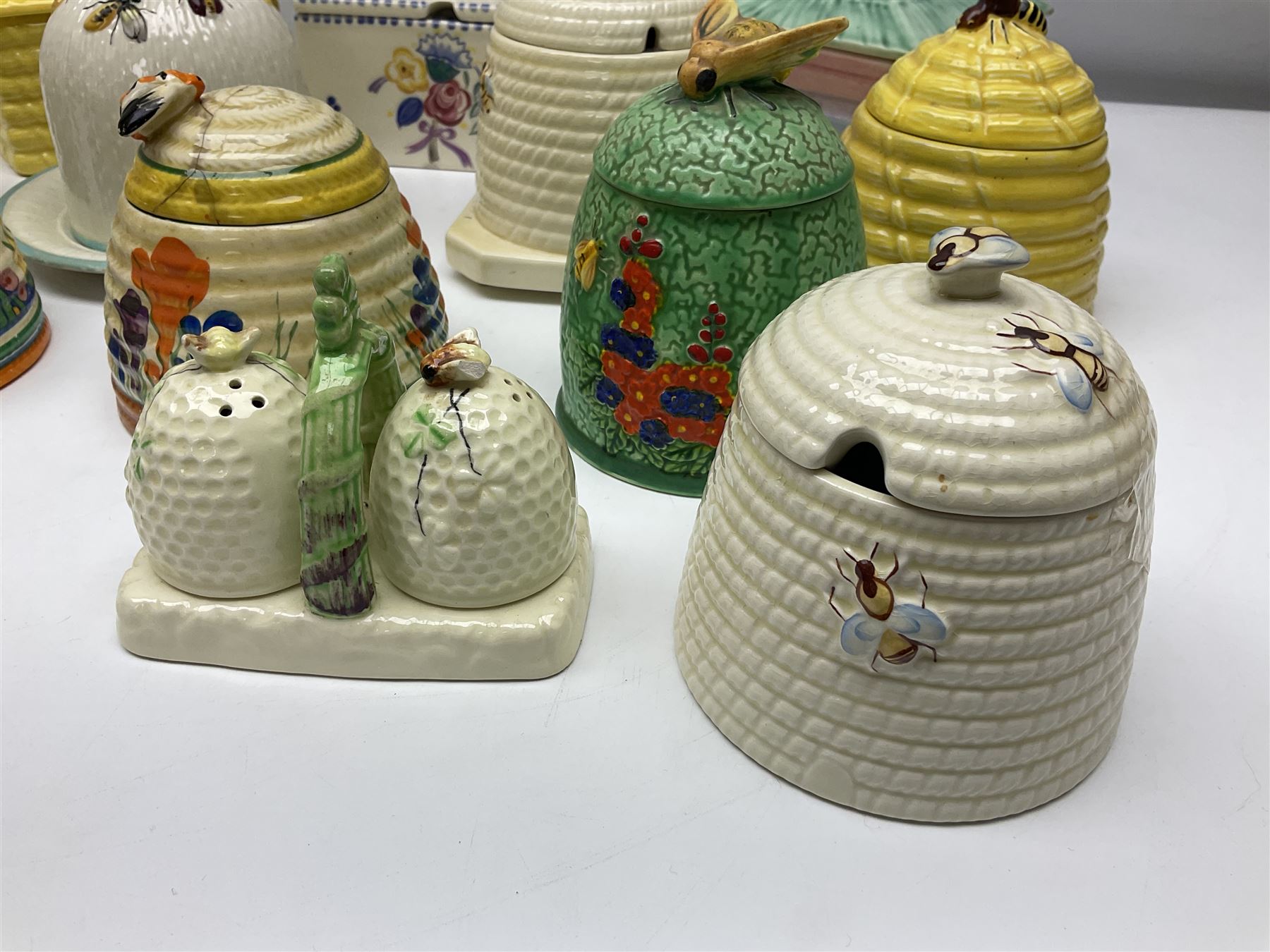 Clarice Cliff for Wilkinson Ltd Crocus Bizarre beehive honeypot painted in the Crocus pattern, together with two beehive Beswick honey pots, Poole square honey pot etc (14)