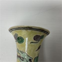 20th century Chinese Famille Verte vase, of slender ovoid form with tapering neck and flared rim, decorated with green and grey enamel with dragons chasing flaming pearls amongst auspicious clouds upon a yellow ground, H30cm
