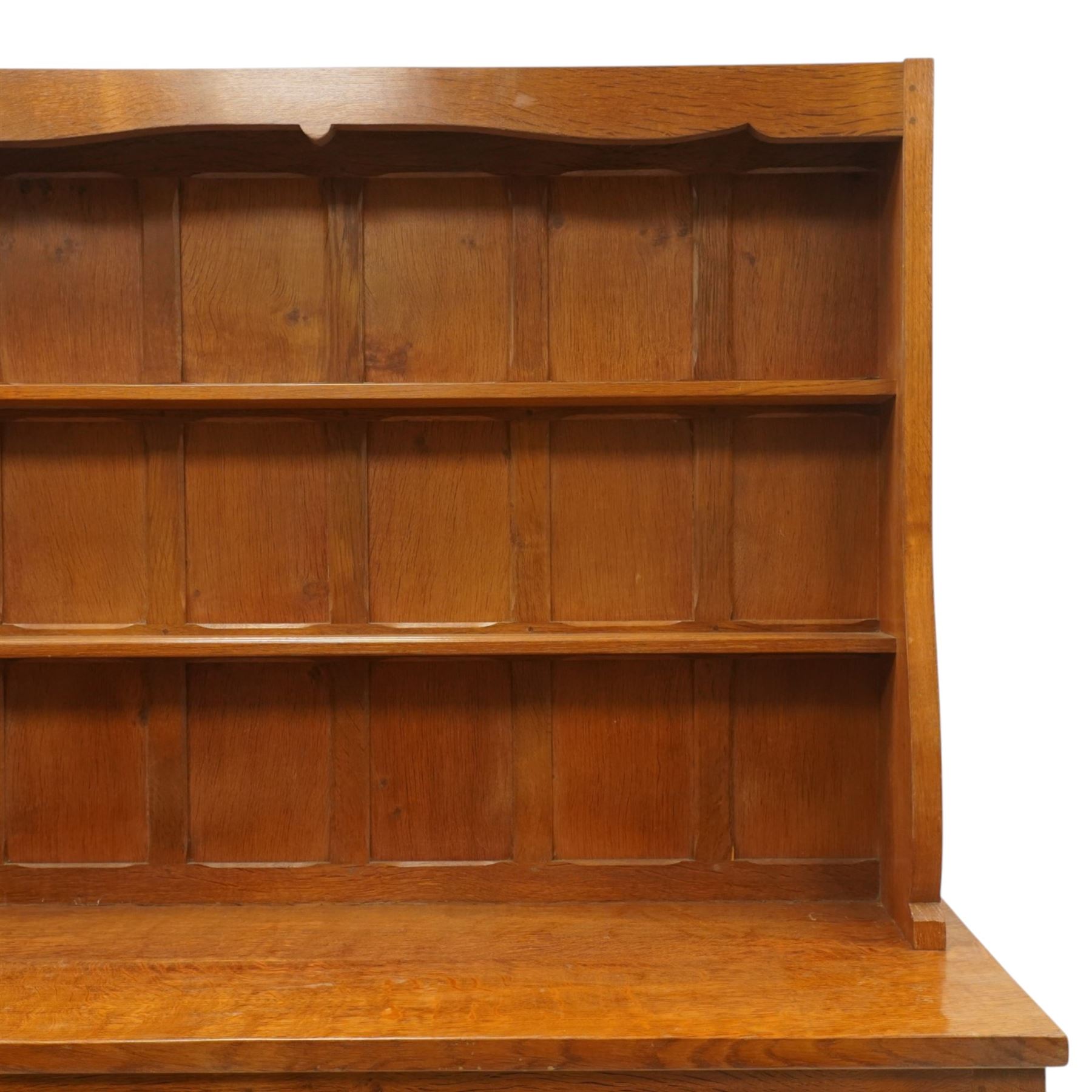 Cat and Mouseman - adzed oak dresser and plate rack, plate rack with two delf rack, panelled back and shaped uprights, above a base with two short drawers and turned wooden handles, panelled cupboard doors and sides, raised on a plinth base, with carved Cat and Mouseman signature, by Lyndon Hammell of Harmby
