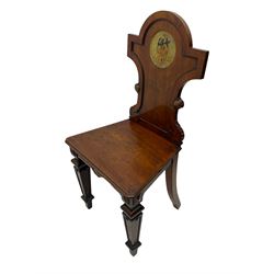 Set of four 19th century mahogany hall chairs, the shaped back with circular naval crest, applied moulded frame with scrolled terminals, canted moulded seat on square tapering supports with recessed panels, decorated with geometric rectangular and circular mounts