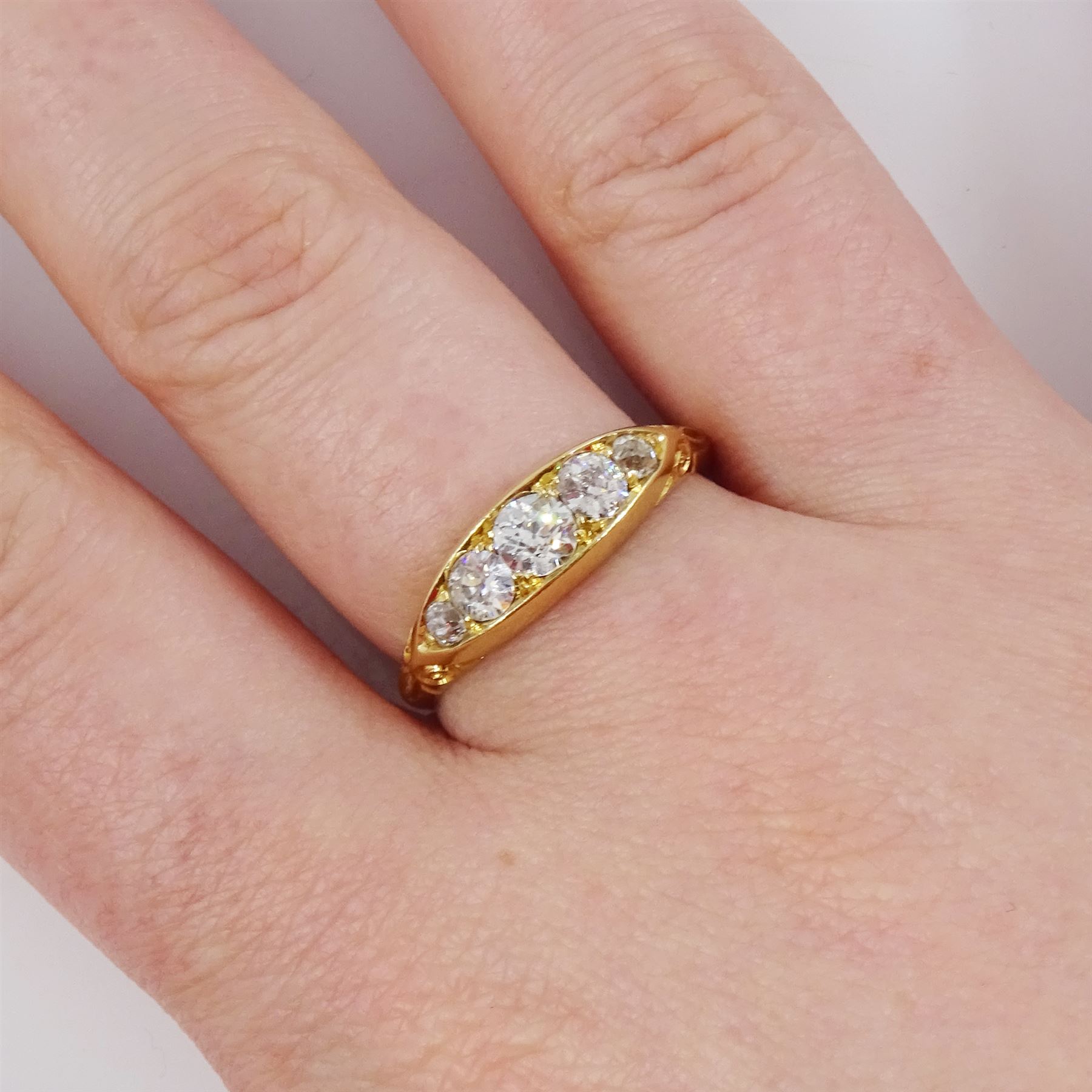 Early 20th century 18ct gold five stone diamond ring, set with five graduating old cut diamonds, with scroll design shoulders, hallmarked, total diamond weight approx 0.60 carat