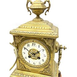 French gilt metal mantle clock c1900, the domed case surmounted by an urn with rococo swags, with circular side handles on a spreading base with four splayed feet, dial bezel with an egg and dart slip, enamel dial with an applied pierced gilt centre, gothic Arabic numerals, minute markers and steel fleur-de-lis hands, with an eight-day twin barrel countwheel striking movement, striking the hours and half hours on a bell. On a rectangular gesso plinth with velvet pad. With pendulum.


