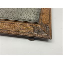 Arts and Crafts oak stand by Arthur Simpson of Kendal, of rectangular form with central hammered pewter panel, surrounded by a border with carved foliate corners, upon two bar supports, bearing label detailed 