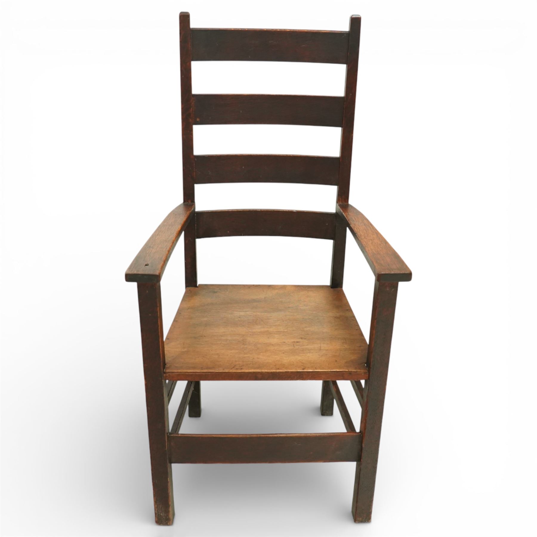Arts and Crafts oak ladder back armchair in the manner of M H Baillie Scott, the high back with shaped slats and plain uprights, over a solid seat and square arm supports, joined by plain stretchers