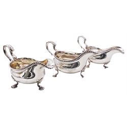 Set of three George III silver sauce boats, each of typical form with gadrooned rim, and acanthus capped scroll handle, upon three shell mounted shell pad feet, one example with engraved crest to body, hallmarked George Methuen, London 1760 including handle H13cm, approximate total weight 44.73 ozt (1391.5 grams)