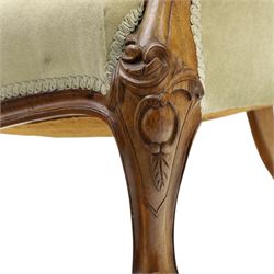 Victorian carved walnut framed armchair with matching stool, the tub-shaped chair with moulded and shaped frame and arm terminals, raised on scrolled cartouche carved supports with scroll feet and castors, buttoned back and sprung seat upholstered in sage green fabric; the small circular footstool with buttoned seat and scroll supports (W36cm H15cm)