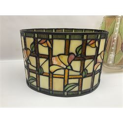 Tiffany style lamp shade, of oval form, with pale peach flowers on a cream and orange lattice ground, together with three other Tiffany style lamp shades and a moulded glass lamp shade with four coloured panels, oval Tiffany style W28.5cm