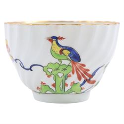 Chamberlain's Worcester teabowl and saucer, each of wrythen form decorated in the Sir Joshua Reynolds pattern, circa 1800, with long tailed Ho Ho bird perched upon green rockwork and surrounded by flowering vines, the saucer with iron red pattern number 203 beneath, teabowl H6cm D8.5cm, saucer D14cm