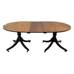 Georgian design mahogany twin pedestal dining table, oval top with reeded edge, single additional leaf, on turned pedestal with four out splayed supports, cast brass hairy paw castors 