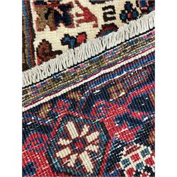 North West Persian Heriz carpet, the red ground field with large star medallion surrounded by stylised plant motifs, ivory ground spandrels with stylised leaf decoration, repeating guarded border