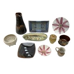 Collection of studio pottery to include Guy & Pip Perkins rectangular dish in blue glaze with geometric design, raku bowl raised upon three legs impressed 'GF', slipware mug modelled as a stylised sea creature, large pitcher with impressed 1951 plaque, together with other studio pottery with various marks (10)