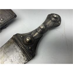 Late 19th/20th century Middle Eastern jambiya dagger the 36cm broad curved double edged steel blade with traces of script, horn and copper backed waisted white metal hilt with three roundel buttons; in ornate white metal and leather mounted brass and steel scabbard L60.5cm overall