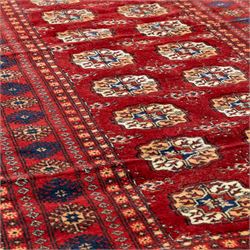 Two hand-knotted rugs, comprising Persian floral rug, dark blue ground decorated with scrolling foliage and flowerheads within a red floral border (H 208cm, W 134cm); Bokhara type rug, red ground with repeating gul motifs and geometric guard borders (H 174cm, W 94cm)