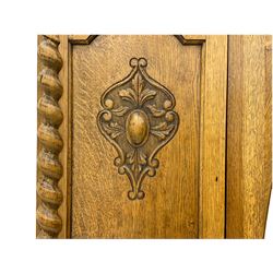 Early 20th century oak wardrobe, projecting cornice of blind fret-work frieze, oval bevel edge mirror door, half spiral turned pilasters, drawer to base with mouldings, on turned bun feet