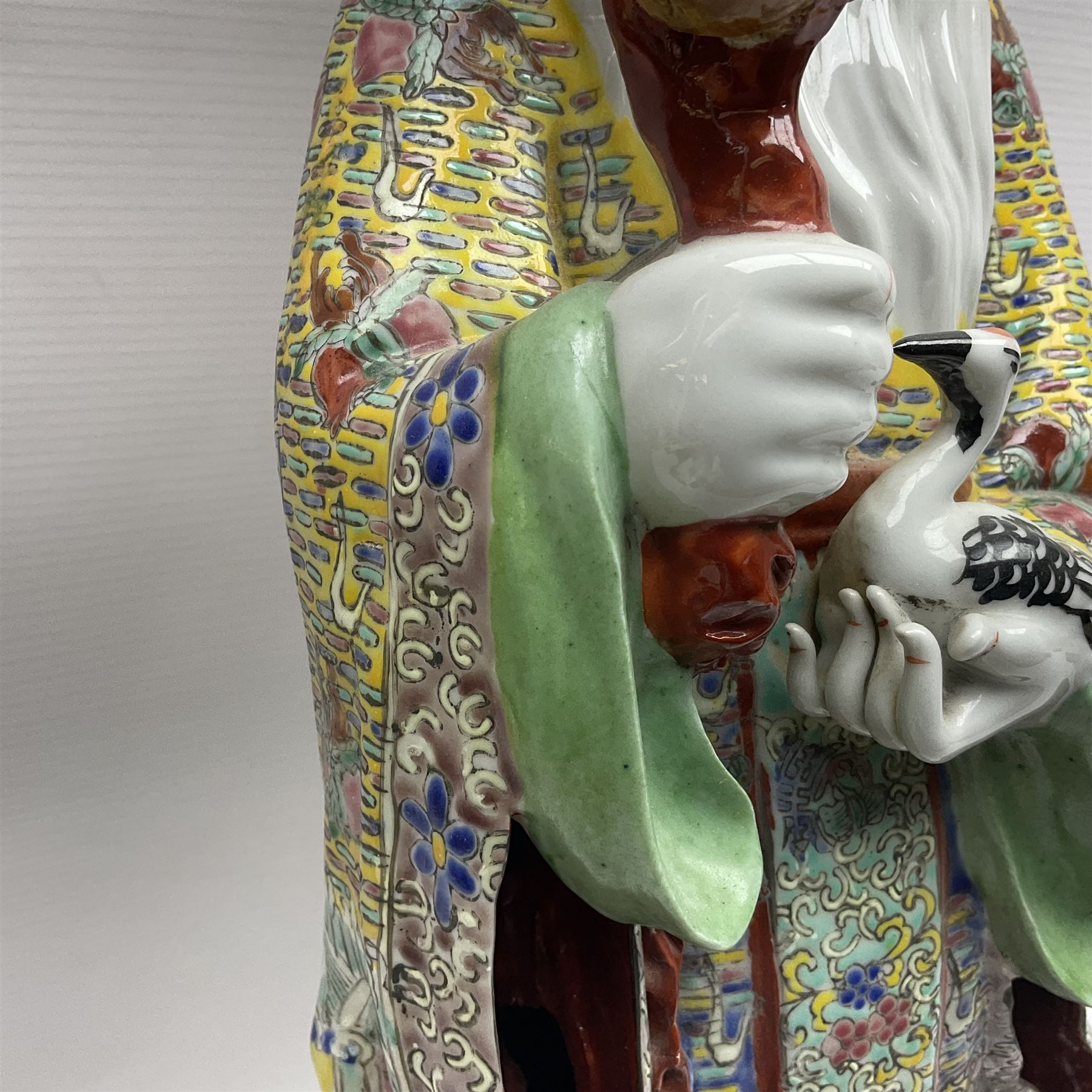 Chinese Republic Period porcelain figure, modelled as Shoulao, wearing elaborately enamelled robes decorated with peaches and flower heads, with impressed mark beneath, H55cm