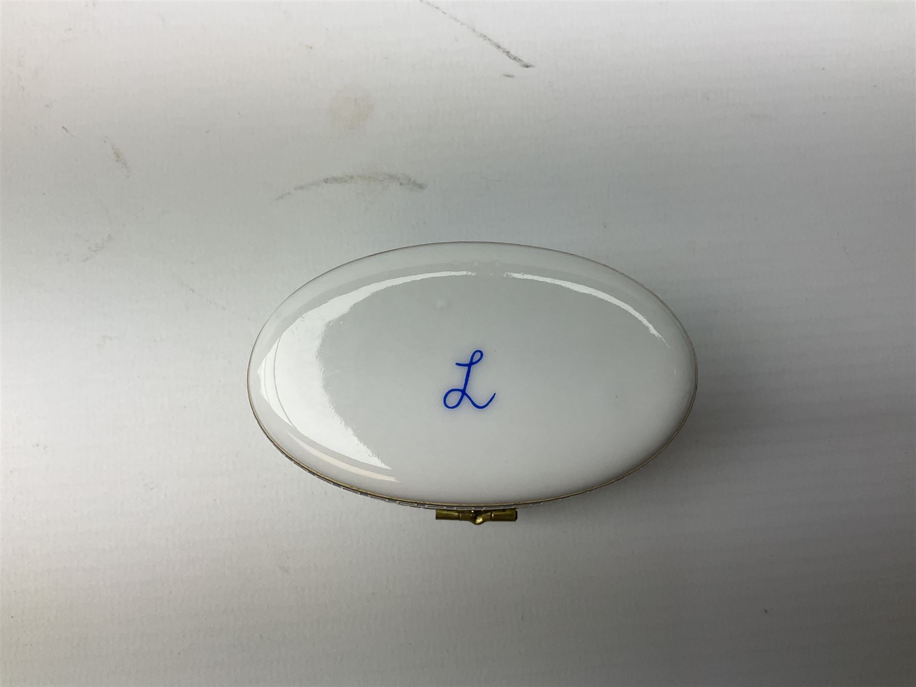 Late 19th Century pot lid bearing ‘The Residence of Anne Hathaway, Shakespeare’s Wife’ below printed decoration of thatched houses and animals scene, Royal Crown Derby Chinoiserie pattern coffee can and saucer, Rd No 758225, and an oval trinket box with gilt decoration bearing interlaced L mark to base (4)