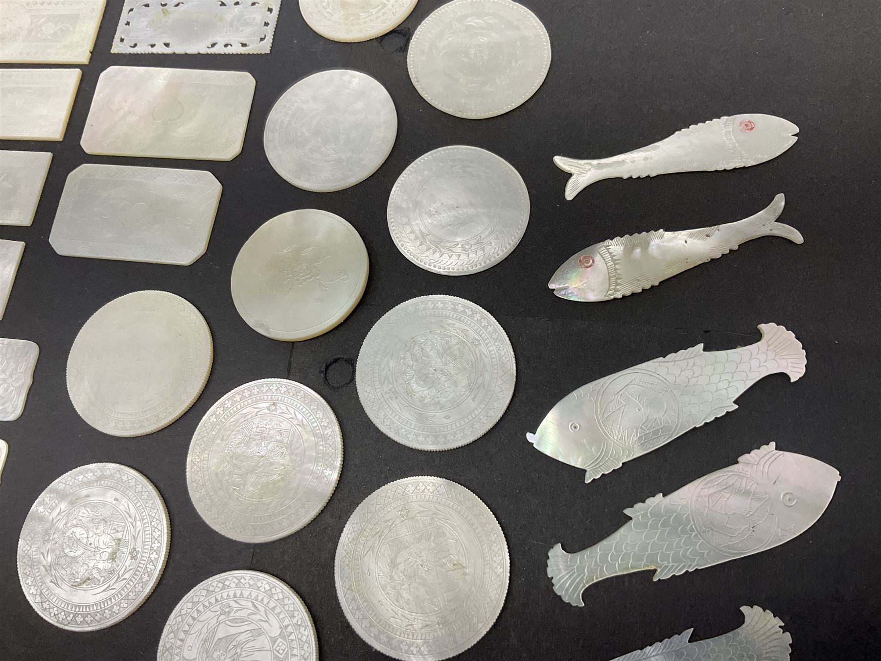Collection of fifty seven Chinese mother of pearl gaming counters or tokens, of various size and form including rectangular, circular and fish shaped examples, various decoration including floral motifs, largest rectangular examples L6cm