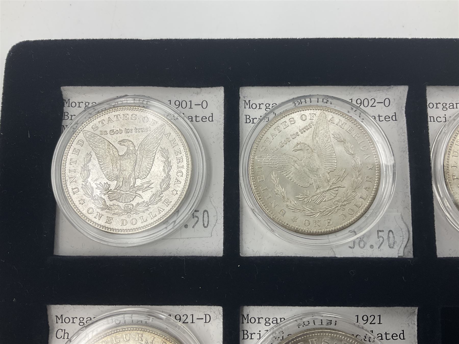 Seven United States of America silver Morgan dollar coins, dated 1884, 1901 O, 1902 O, 1903, 1904 O, 1921 D and 1921