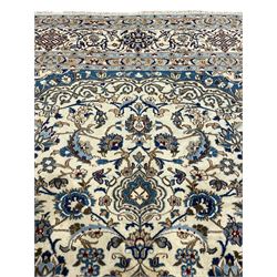 Persian Nain ivory ground carpet, the field decorated all over with leafy branches and stylised flower head motifs, blue ground central medallion and matching spandrels decorated with trailing foliate pattern, repeating guarded border with overall floral design