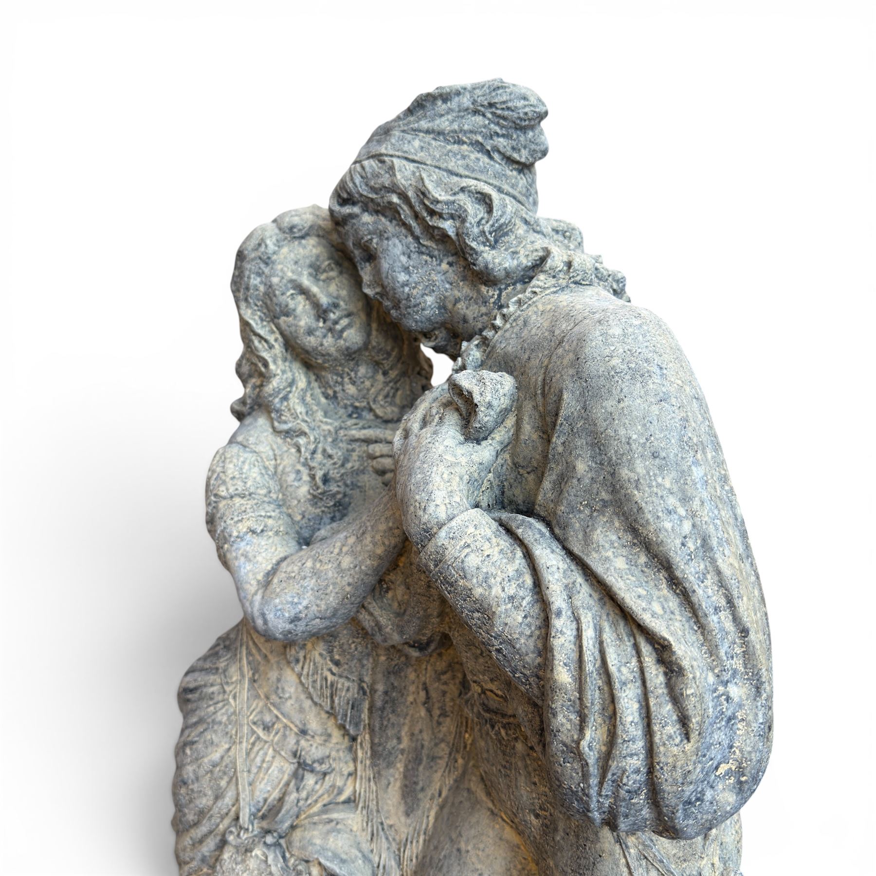 Composite garden statue group of Romeo and Juliet embracing, the couple adorned in Medieval dress standing on a naturalistic base with fallen flowers, raised on a Neoclassical fluted pedestal with Anthemion leaf motifs