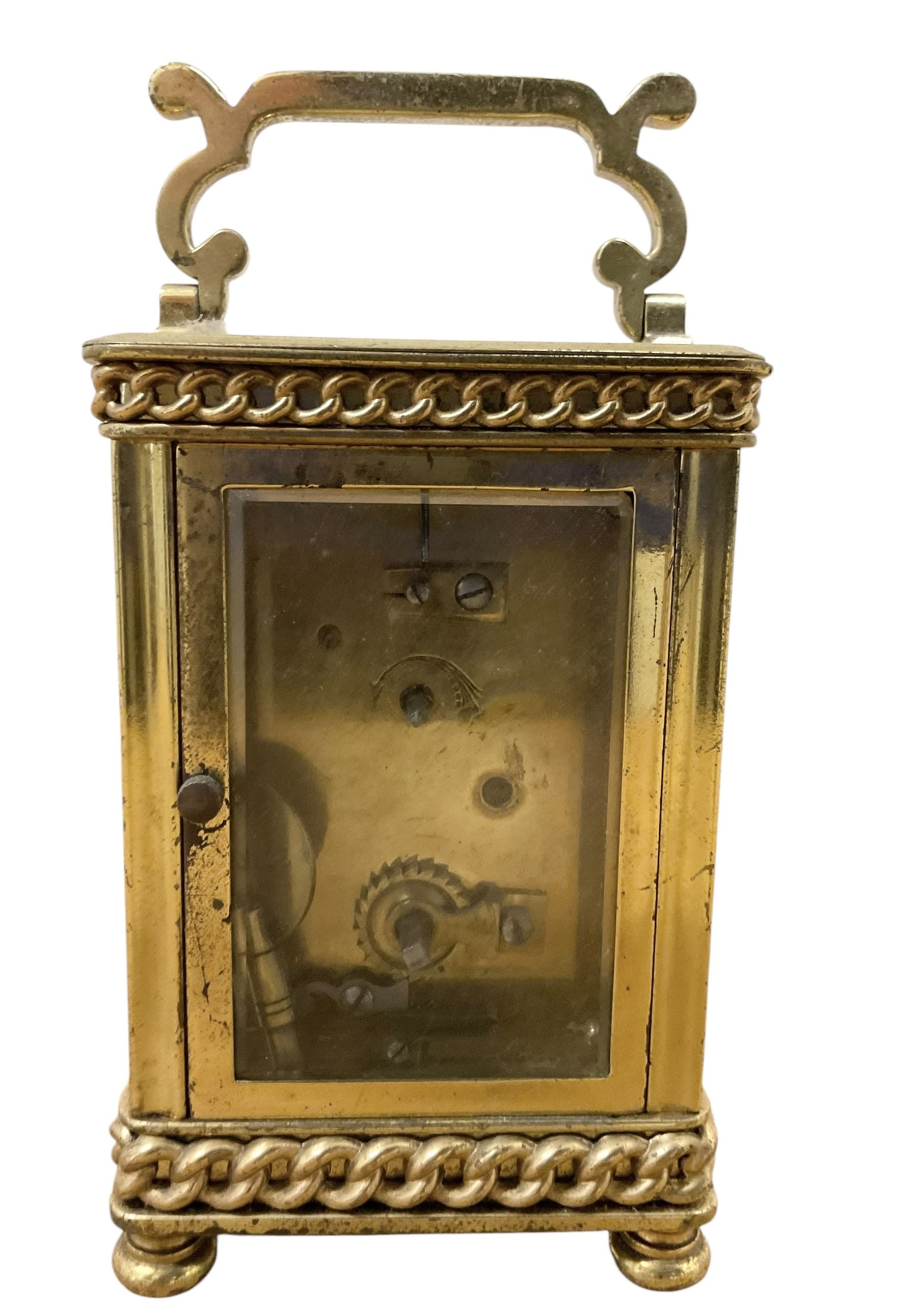 French- Edwardian 8-day carriage clock c1910, with recessed chain decoration and a serpentine handle, four recessed glass panels raised on bun feet, decorative enamel dial with floral swags, Arabic numerals and matching steel hands, single train movement with a cylinder platform escapement. With key.
