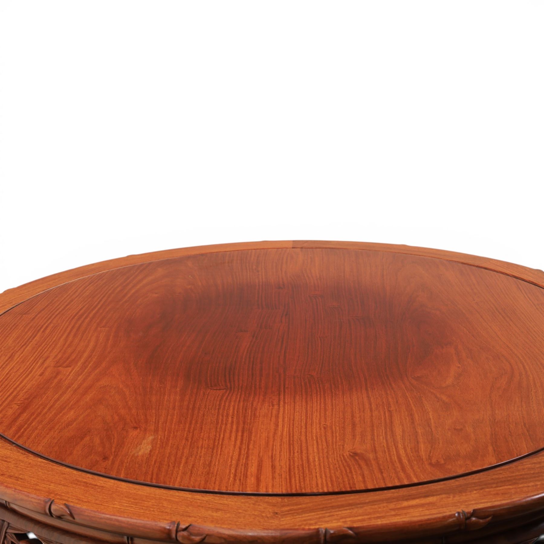 20th century Chinese ornately hardwood dining table and chairs, circular table with 'Lazy Susan' top with pierced carved frieze, raised on a quadriform base with carved foliate detail, the chairs en suite with carved pierced detailing  