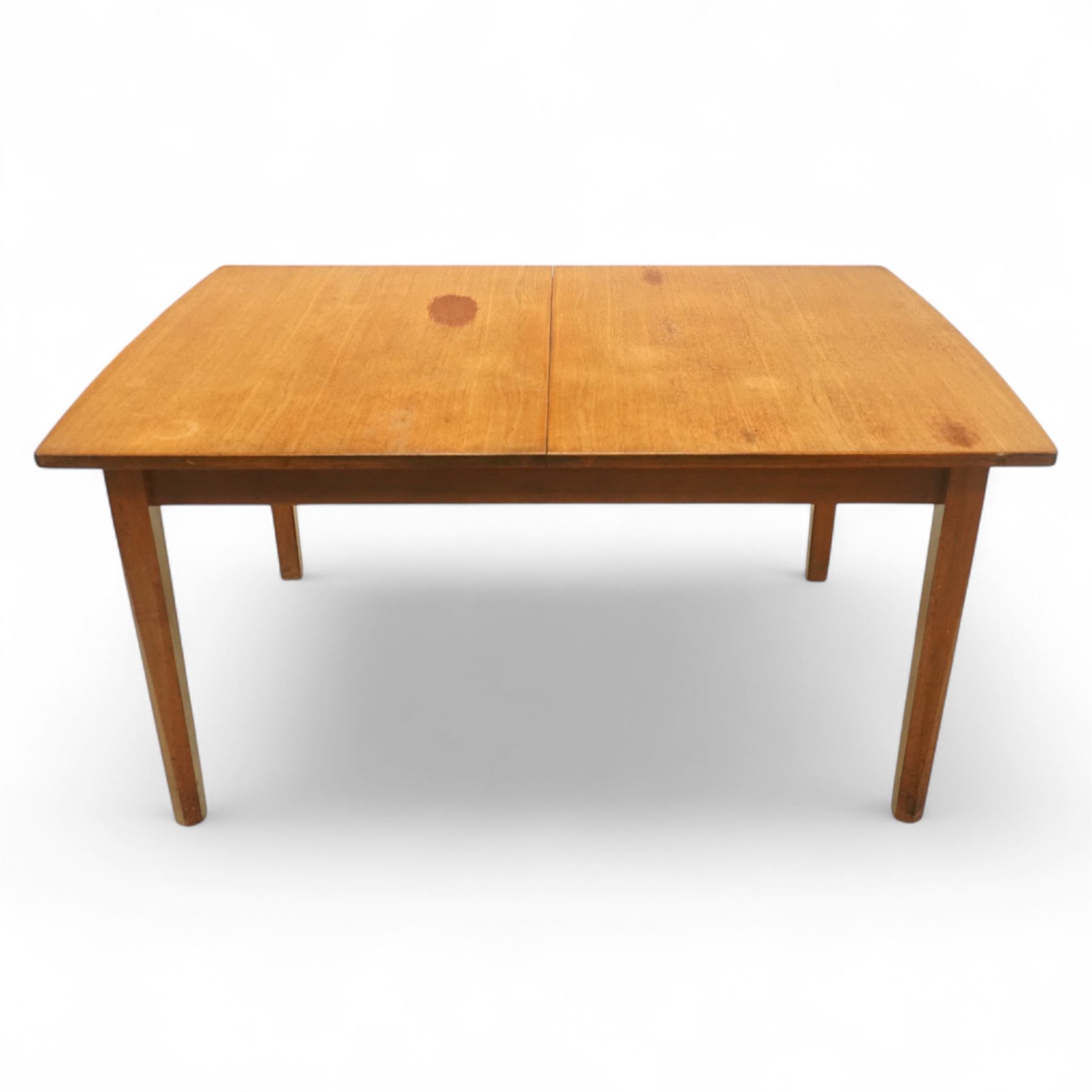 Mid-century Dutch teak extending dining table, rectangular top with lightly chamfered edge incorporating a pull-out extension leaf stowed on the underside, above a plain apron and raised on four square tapering chamfered legs, unextended length 140cm