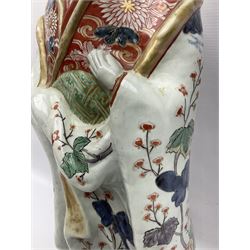 Large Japanese Imari porcelain figure, modelled as a Bijin, wearing a long kimono decorated with apple blossom and leafy branches on a white ground, with gilt detailing, possibly Edo period, H63cm