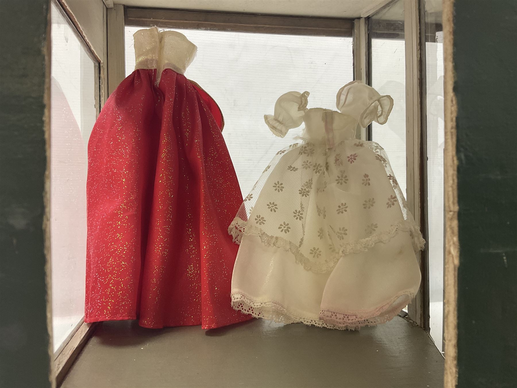 Early 20th century scratch-built wooden hat & gown shop diorama 'Joan', of double-fronted form glazed on three sides with brass and aluminium mounts, rear access apertures and storage under L63cm H45cm D31cm; with small collection of dresses and hats on display stands