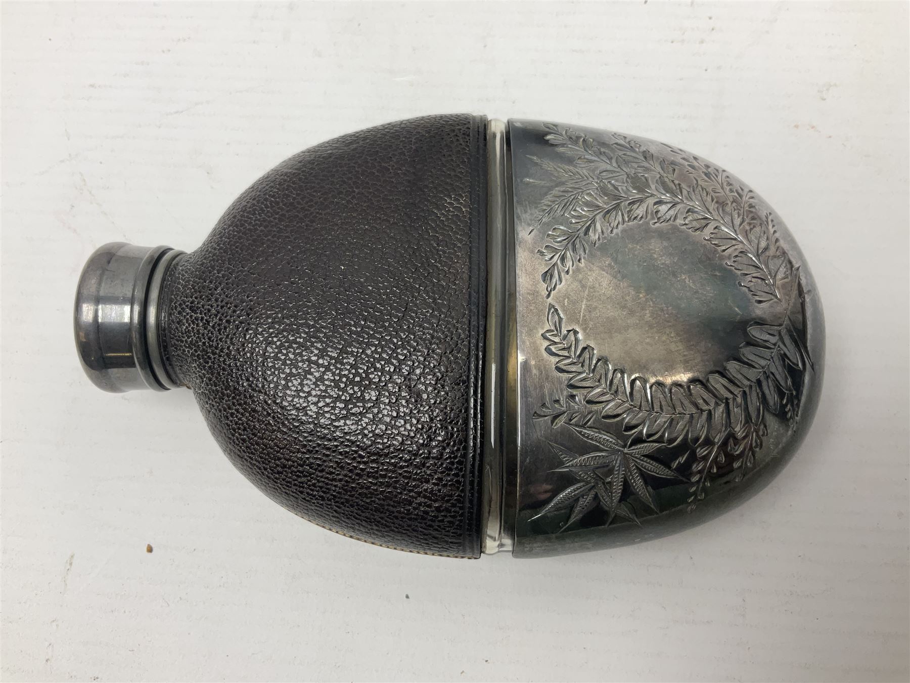Silver plated glass and pressed leather hip flask, with swivel cap and removable cup, together with a similar oval example, engraved with wreath and initial B, tallest H16.5cm