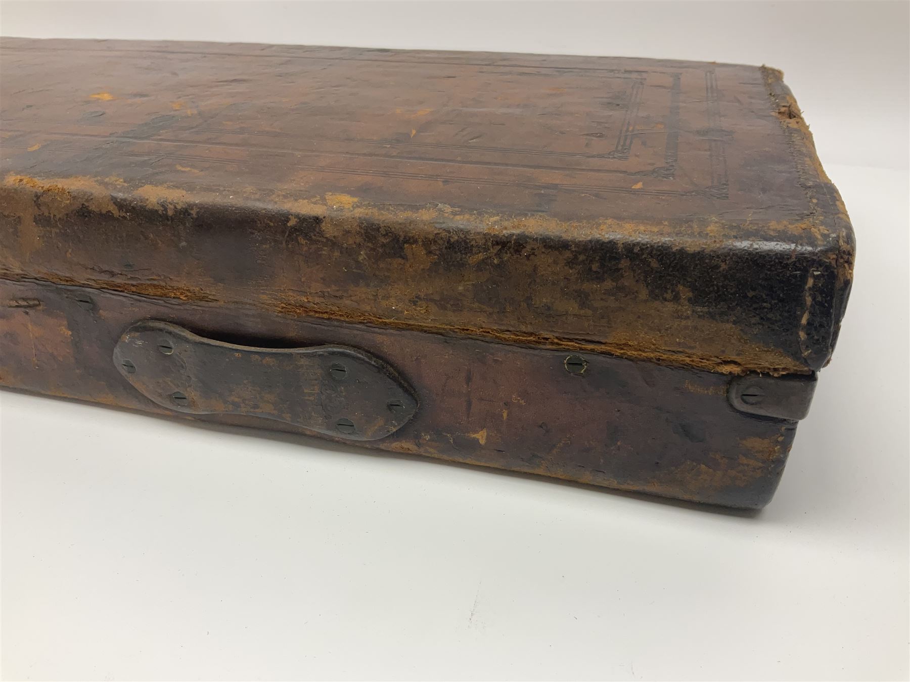 Leather shotgun case, the red baize lined interior with the trade labels of Westley Richards & Co., London, a brass plaque inscribed 'T Nevin, Mirfield, Yorkshire' to cover, with key, case to fit barrel 76cm (30 inches)  
